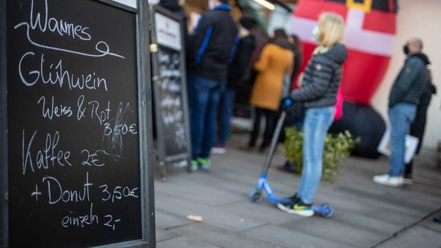 Menschen stehen an einem Glühwein-Stand