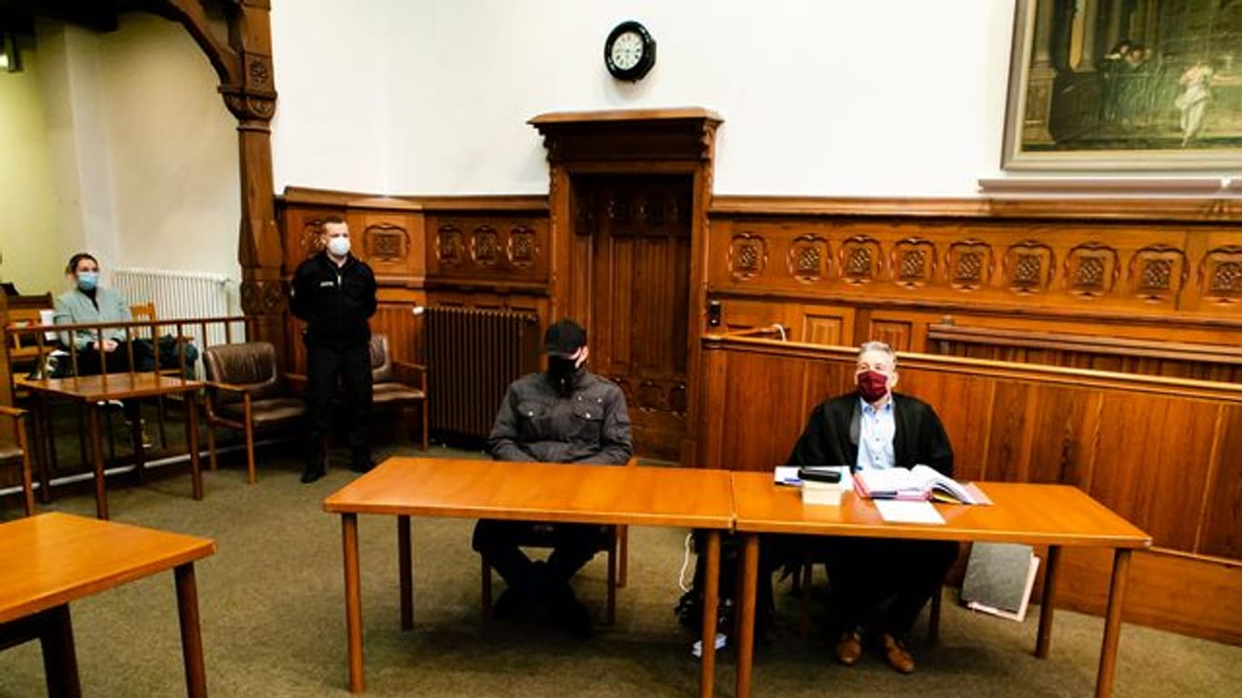 Der Angeklagte und sein Verteidiger sitzen im Gerichtssaal im Flensburger Landgericht.
