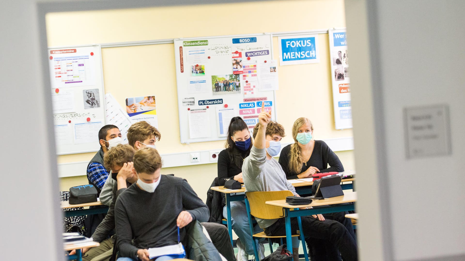 Schüler einer Klasse sitzen mit Mund-Nasen-Bedeckungen im Unterricht (Symbolbild): Für Schüler und Lehrer sind die Lern- und Arbeitsbedingungen wegen der Corona-Regeln schwieriger geworden.