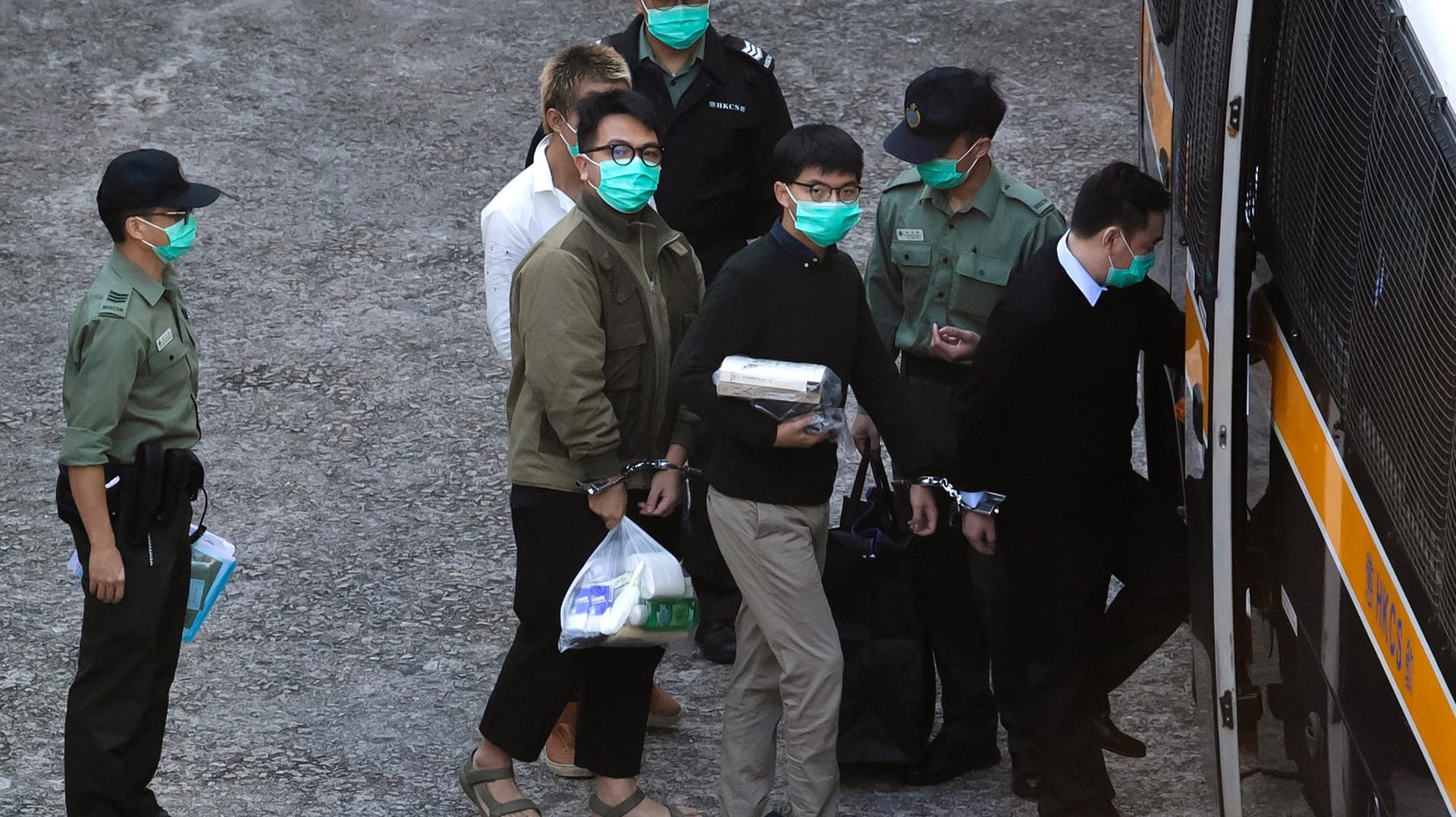 Ivan Lam (Mitte, l) und Joshua Wong (Mitte, r) steigen in einen Gefangenentransporter ein: Die Aktivisten wurden verurteilt. Ivan Lam (Mitte, l) und Joshua Wong (Mitte, r) steigen in einen Gefangenentransporter ein: Die Aktivisten wurden verurteilt.