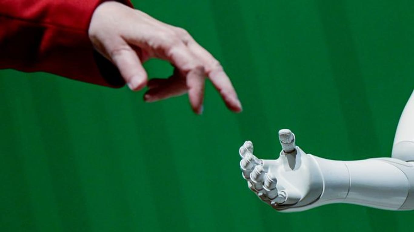 Ein Roboter interagiert beim "Speed Dating mit KI - Meet the Robots bei KI-Tagen" im Hammerbrooklyn Digital Campus mit einer Frau.