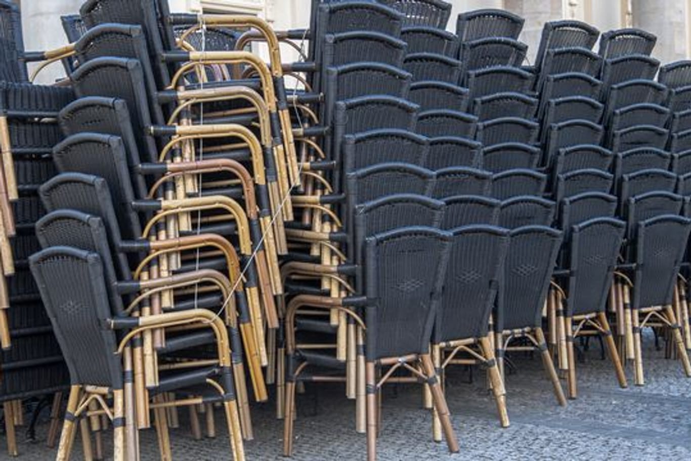 Zusammengestellte Stühle stehen vor einem gastronomischen Betrieb in Potsdam.