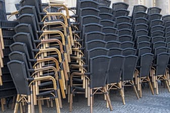 Zusammengestellte Stühle stehen vor einem gastronomischen Betrieb in Potsdam.