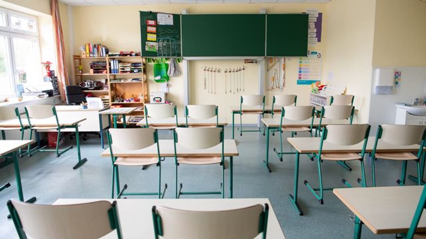 In einem menschenleeren Klassenraum einer Grundschule sind die Stühle hochgestellt.