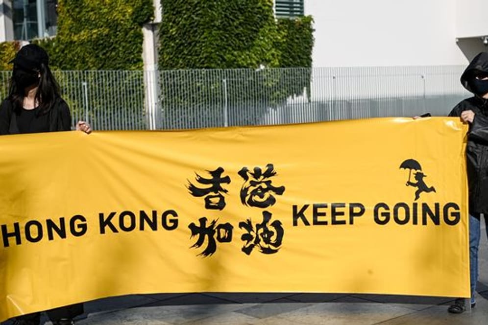 Zwei junge Frauen halten ein Transparent mit der Aufschrift "Hong Kong keep going" bei einer Menschenrechtsaktion vor dem Bundeskanzleramt.