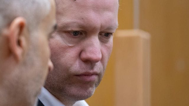Der Hauptangeklagte Stephan Ernst steht mit seinem Verteidiger hinter der Anklagebank.