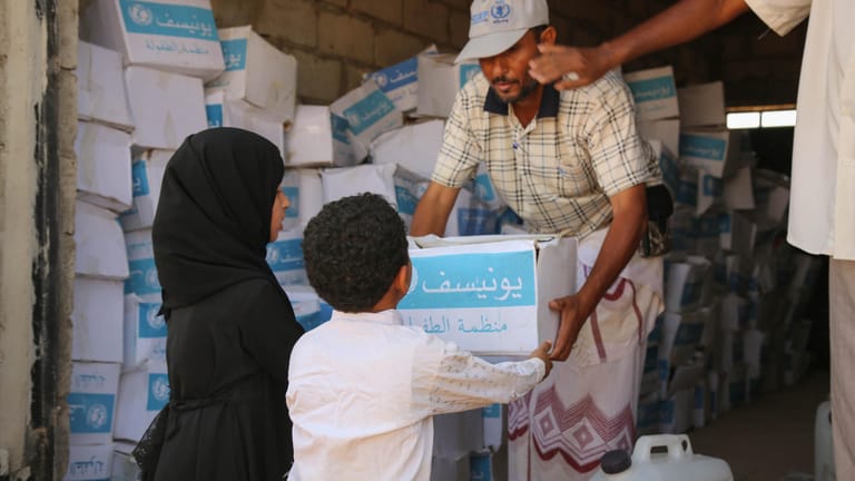Im Jemen werden Care-Pakete an zwei Kinder verteilt: In dem Land Jemen braucht jeder zweite Mensch tägliche Überlebenshilfe durch die UN.