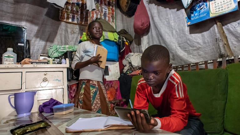 Die zehnjährige Janet und ihr elfjähriger Bruder Samuel lernen daheim in Nairobi, Kenia, mit dem einzigen Handy der Familie: "Geld zu verdienen ist hart im Moment", sagt ihr Vater Moses. "Ich würde es lieber für Maisgrieß ausgeben als für Datenpakete."