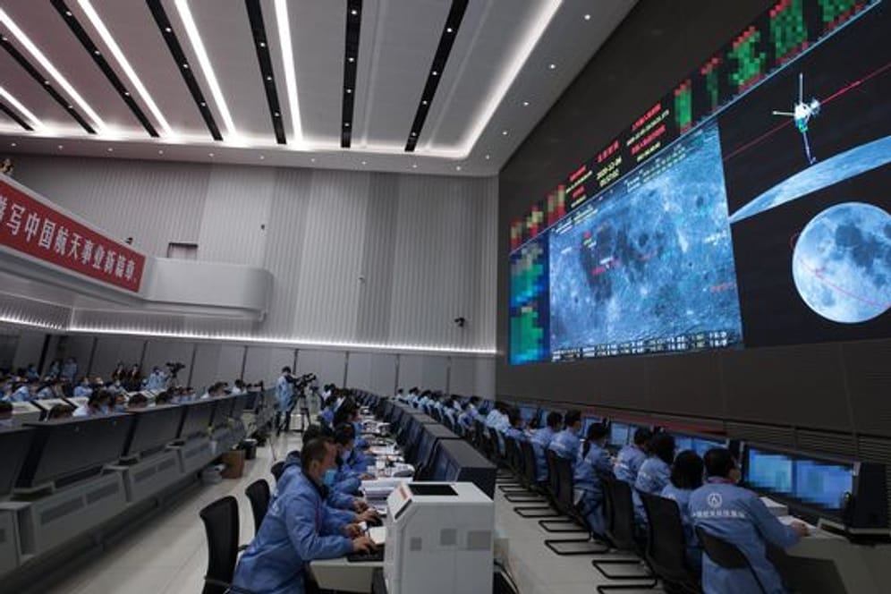 Technisches Personal überwacht den Transfer der auf dem Mond gesammelten Proben vom Aufstiegsmodul zum Rückkehrer der chinesischen Sonde "Chang'e 5" im Beijing Aerospace Control Center.