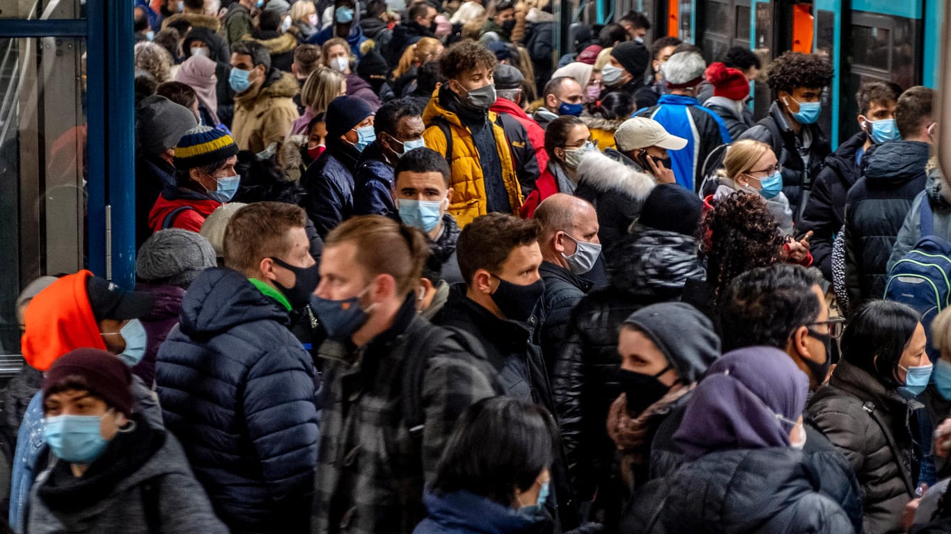 Menschen mit Masken drängen sich in eine U-Bahn in Frankfurt: Die Coronavirus-Fallzahlen in Deutschland bleiben weiter hoch.