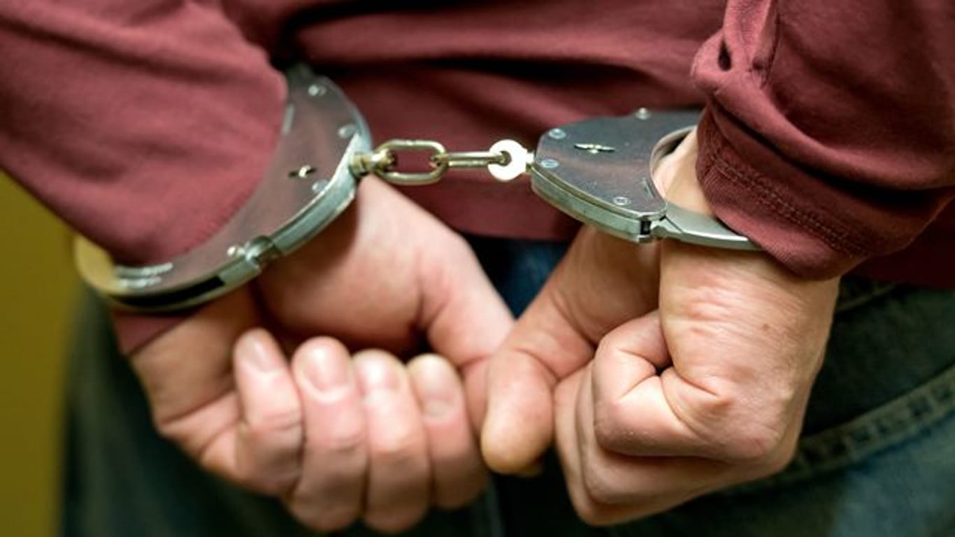 Ein Mann trägt Handschellen (Symbolbild): Ein 53-Jähriger Vater wurde am Flughafen Düsseldorf festgenommen.