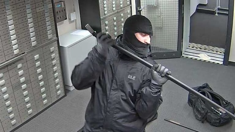 Ein Unbekannter hantiert mit einer Brechstange in der Frohnauer Sparkassen-Filiale: Die Polizei hat die Aufnahmen veröffentlicht.
