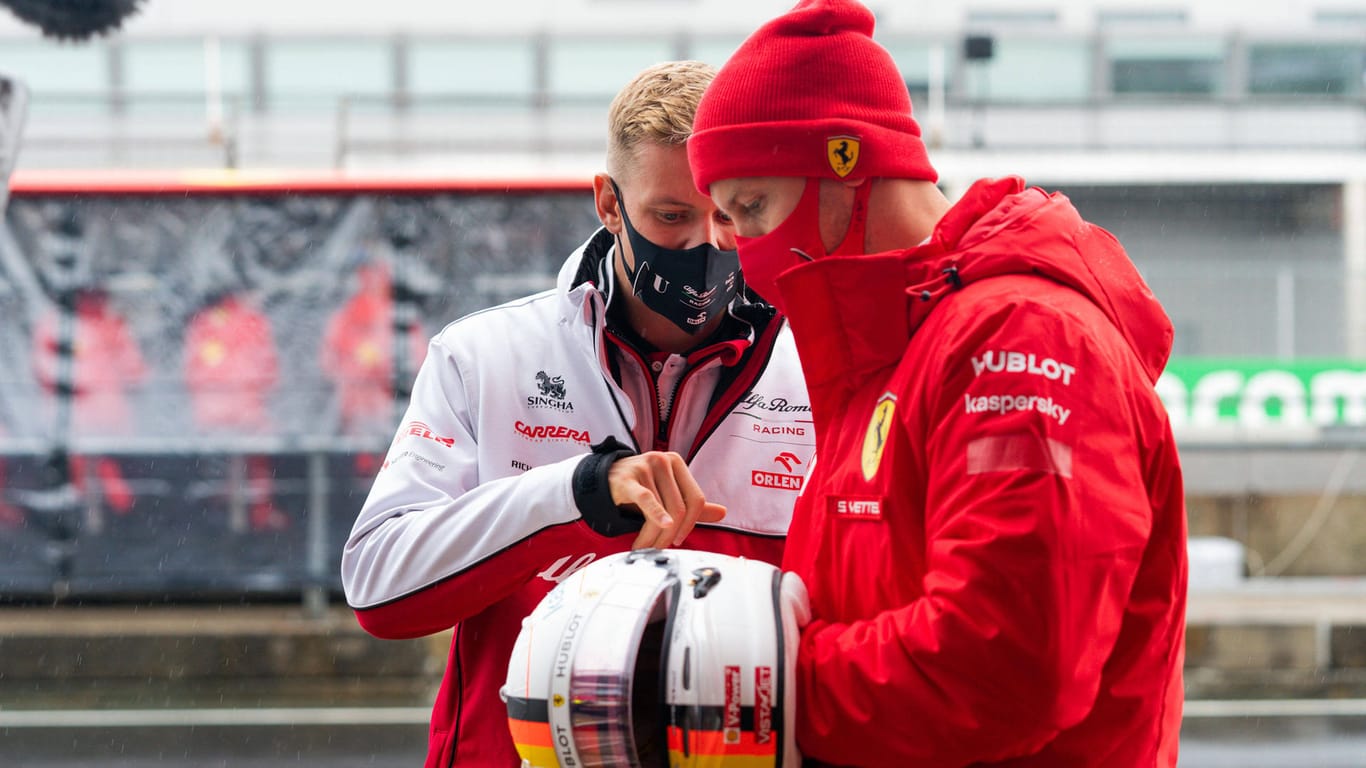 Mick Schumacher und Sebastian Vettel betrachten einen Helm: Mick hatte einen Helm seines Vaters mitgebracht.