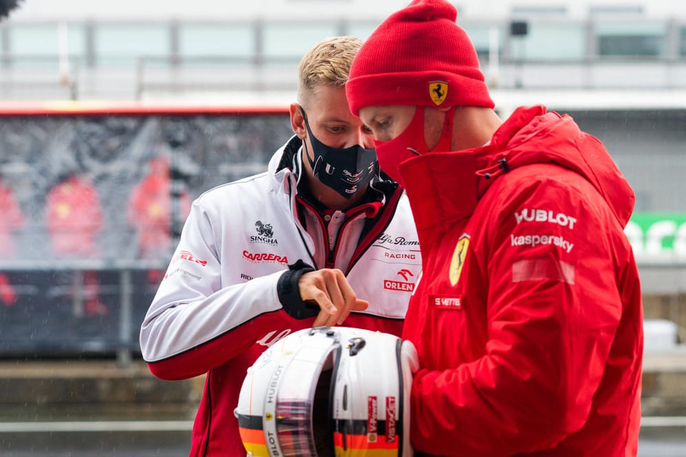 Mick Schumacher und Sebastian Vettel betrachten einen Helm: Mick hatte einen Helm seines Vaters mitgebracht.