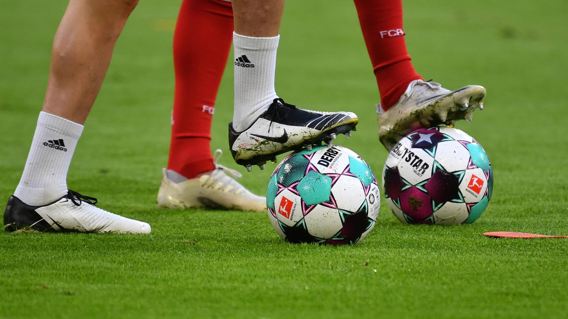 Zwei Spieler stellen einen Fuß auf Fußbälle (Symbolbild): Die nächste Bundesliga-Saison startet im August. Zwei Spieler stellen einen Fuß auf Fußbälle (Symbolbild): Die nächste Bundesliga-Saison startet im August.