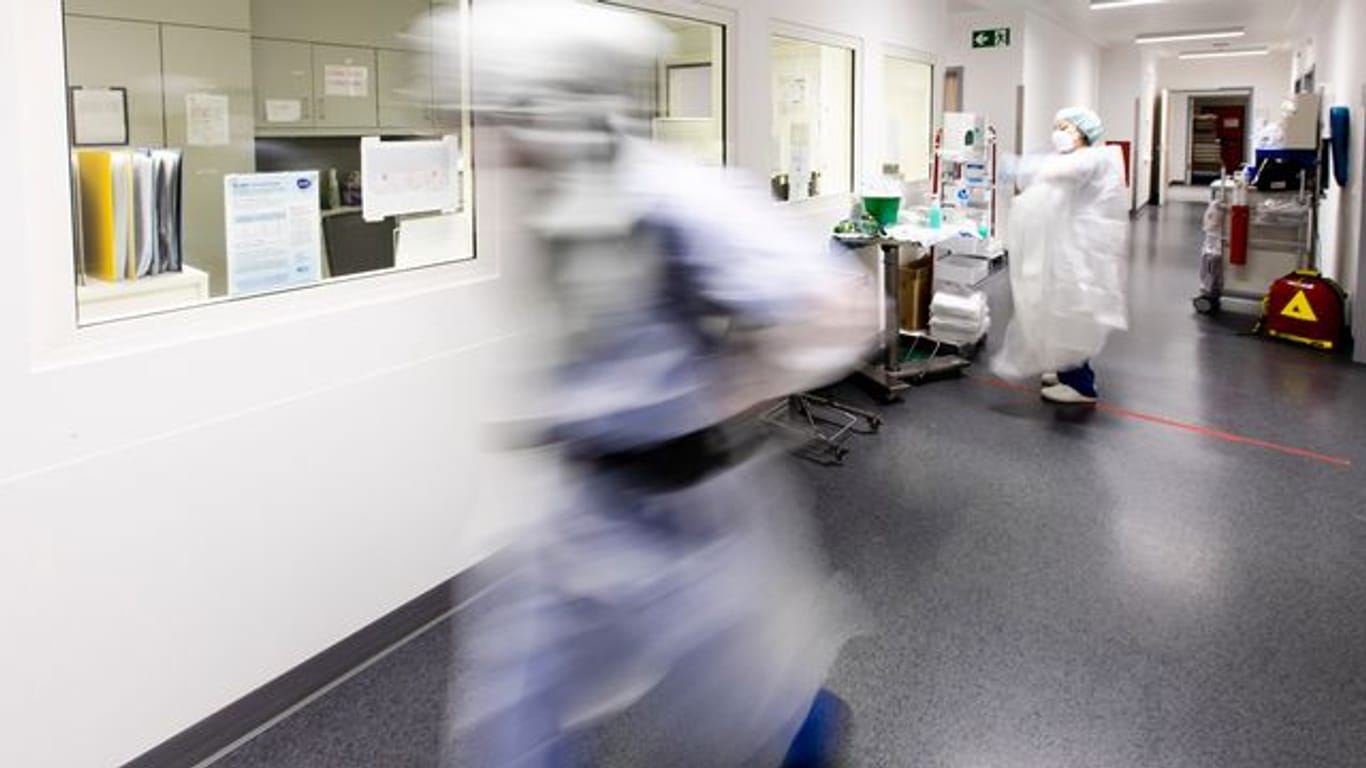 Ein Krankenpfleger läuft über den Flur einer Intensivstation.