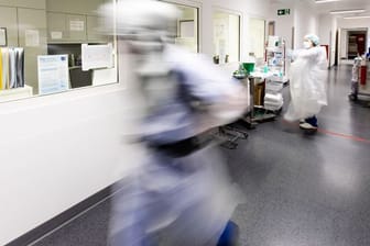 Ein Krankenpfleger läuft über den Flur einer Intensivstation.