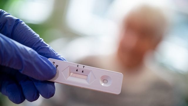 Eine Altenpflegerin hält im Seniorenheim einen Antigen-Corona-Schnelltest in der Hand. Eine Altenpflegerin hält im Seniorenheim einen Antigen-Corona-Schnelltest in der Hand.