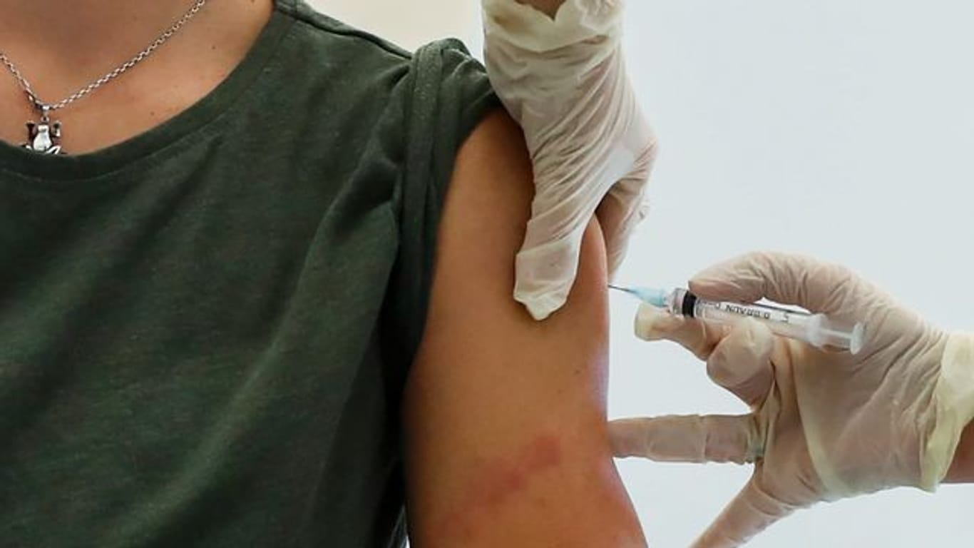 Ein Mitarbeiter des Gesundheitswesens führt in Moskau eine Impfung mit dem Corona-Impfstoff "Sputnik V" durch.