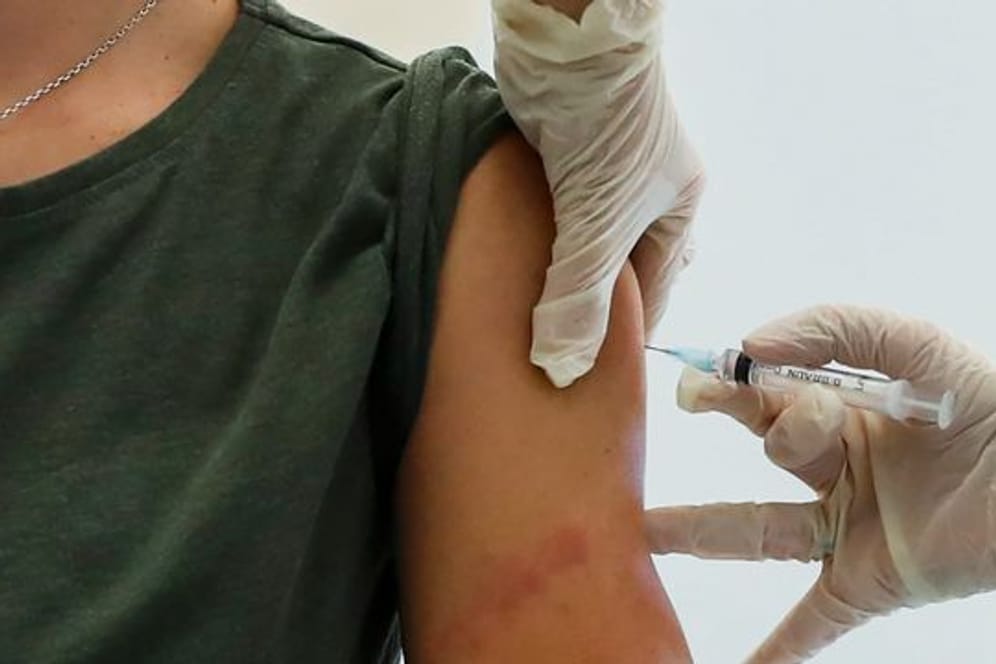 Ein Mitarbeiter des Gesundheitswesens führt in Moskau eine Impfung mit dem Corona-Impfstoff "Sputnik V" durch.