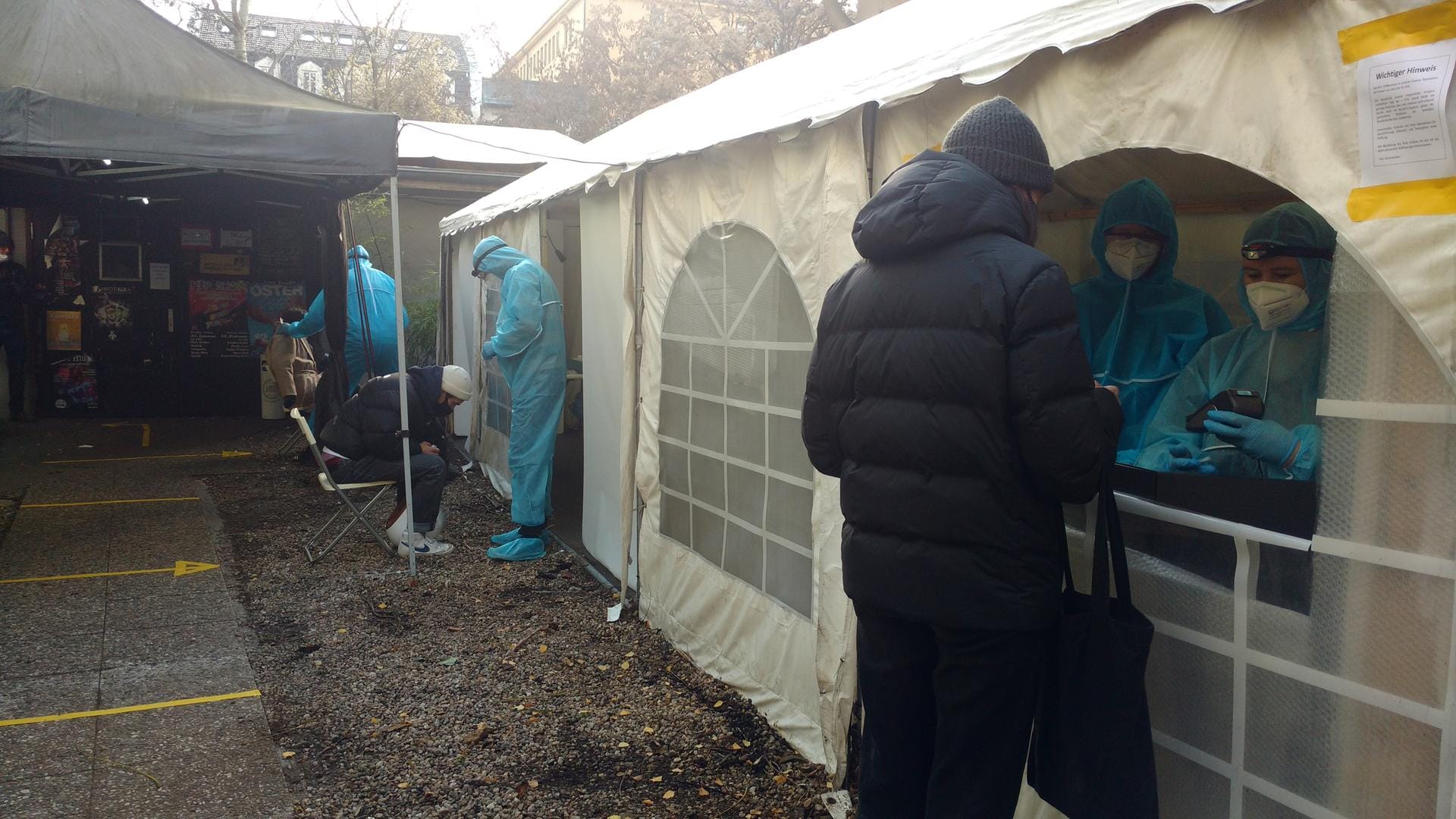 Testassistenten in Schutzanzügen geben Corona-Tests aus und testen Menschen: Schnelltests liefern häufiger falsche Ergebnisse als PCR-Tests.