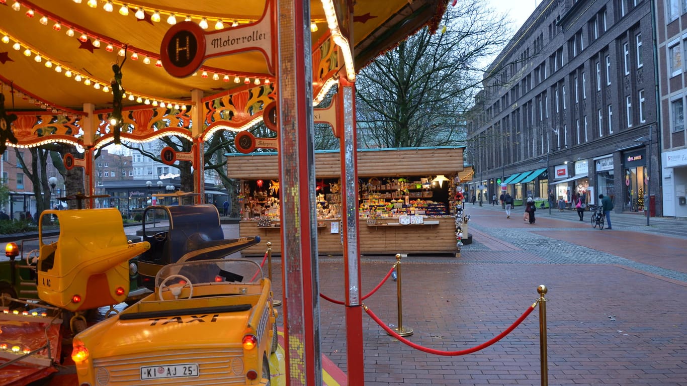 Blick auf ein Karussell und eine Bude auf dem Kieler "Weihnachtsmarkt light": Die Stände sind mit großem Abstand zueinander aufgestellt worden.