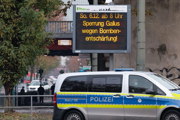 Ein Polizeifahrzeug vor einem Info-Schild: In Frankfurt wird am Sonntag ein Blindgänger entschärft.