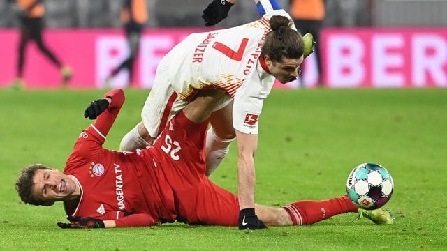 Leipzigs Marcel Sabitzer (o) versucht über dem am Boden liegenden Thomas Müller an den Ball zu kommen. Leipzigs Marcel Sabitzer (o) versucht über dem am Boden liegenden Thomas Müller an den Ball zu kommen.