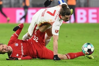 Leipzigs Marcel Sabitzer (o) versucht über dem am Boden liegenden Thomas Müller an den Ball zu kommen.