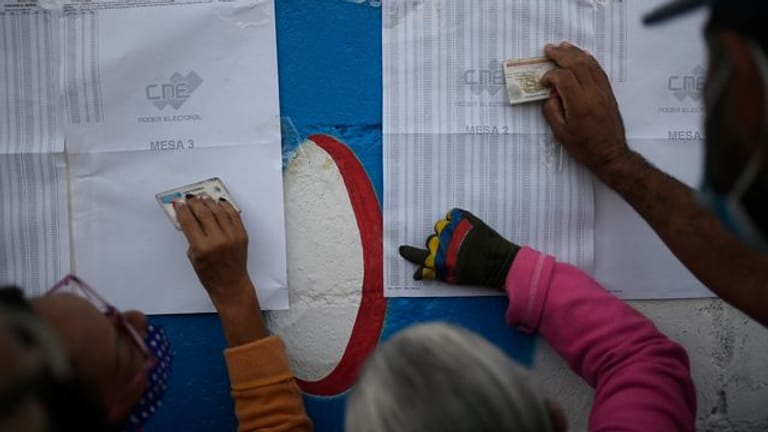 Einwohner von Caracas überprüfen auf einem Aushang, in welchem Wahllokal sie ihre Stimme abgeben müssen.