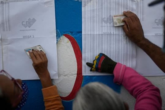 Einwohner von Caracas überprüfen auf einem Aushang, in welchem Wahllokal sie ihre Stimme abgeben müssen.