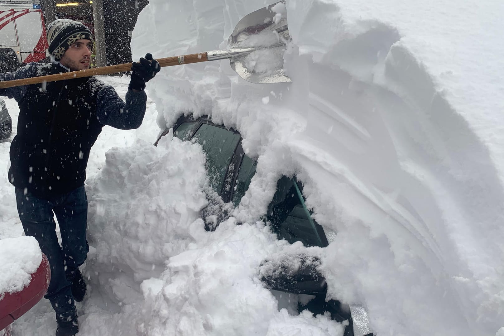 Wintereinbruch in Österreich: Ein Mann befreit mit einer Schaufel sein Auto von den Schneemassen. Große Neuschneemengen haben in Teilen der Alpen zu erheblichen Verkehrsproblemen und höchster Lawinengefahr geführt. In Osttirol in Österreich wurde die höchste Lawinenwarnstufe ausgerufen.