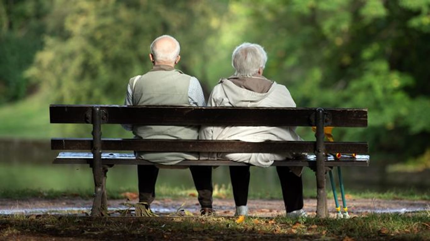 Zwei Senioren sitzen auf einer Bank.