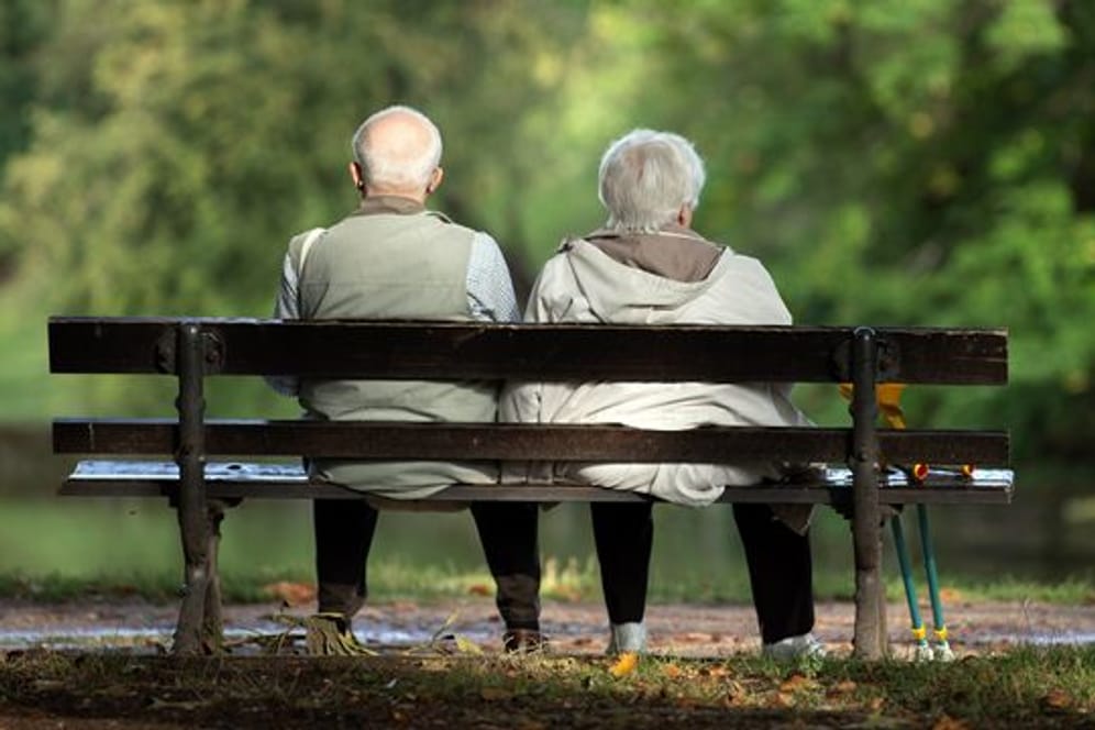 Zwei Senioren sitzen auf einer Bank.