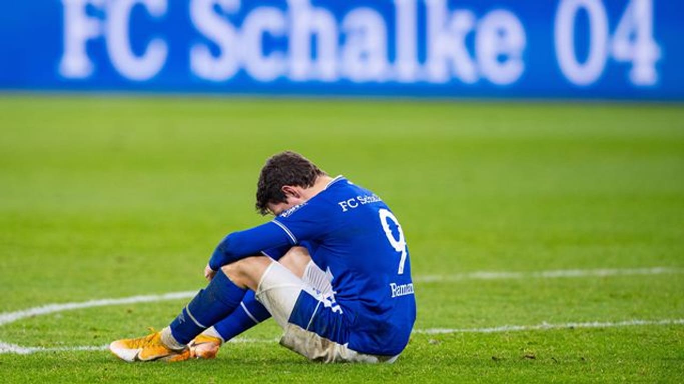 Schalkes Benito Raman sitzt nach dem Abpfiff auf dem Rasen.