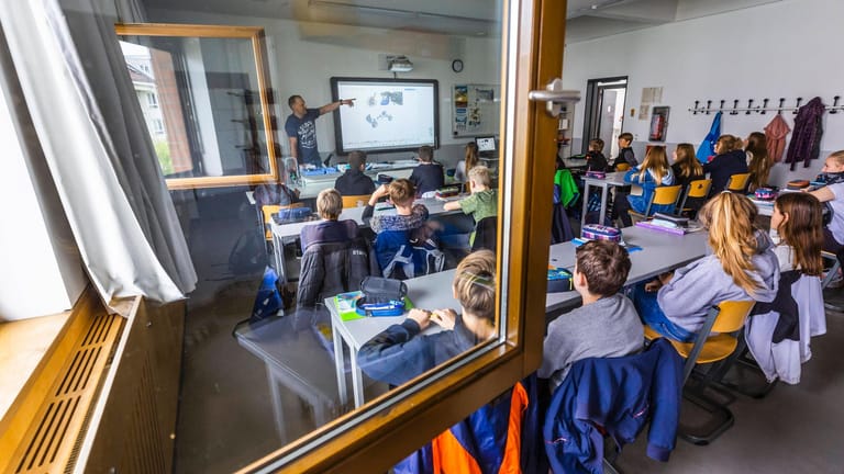 Berliner Schüler und Schülerinnen sitzen bei geöffnetem Fenster im Klassenraum: Tom Erdmann kritisiert die Intransparenz der Corona-Maßnahmen der Berliner Bildungsverwaltung.