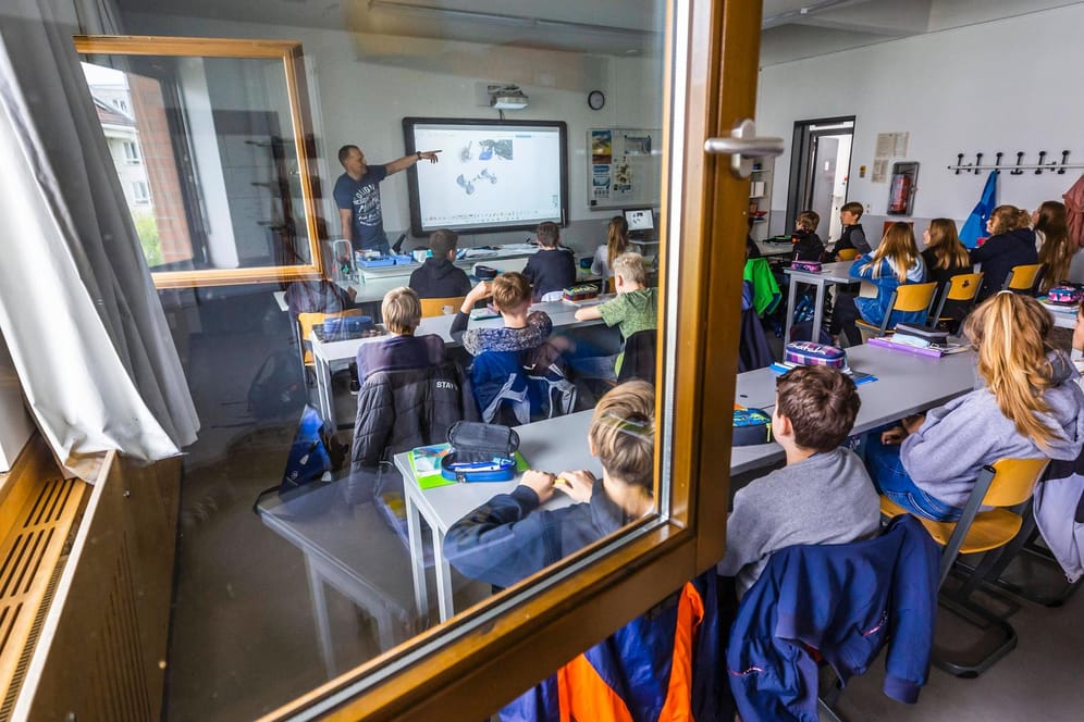 Berliner Schüler und Schülerinnen sitzen bei geöffnetem Fenster im Klassenraum: Tom Erdmann kritisiert die Intransparenz der Corona-Maßnahmen der Berliner Bildungsverwaltung.