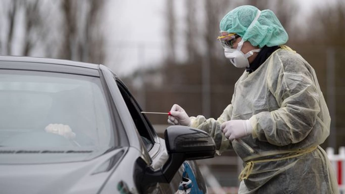 Eine Mitarbeiterin eines Krankenhauses nimmt an einer "Drive-In"-Teststation für das Coronavirus eine Probe (Archivbild): In Frankfurt wurde ein weiteres Testzentrum eröffnet.