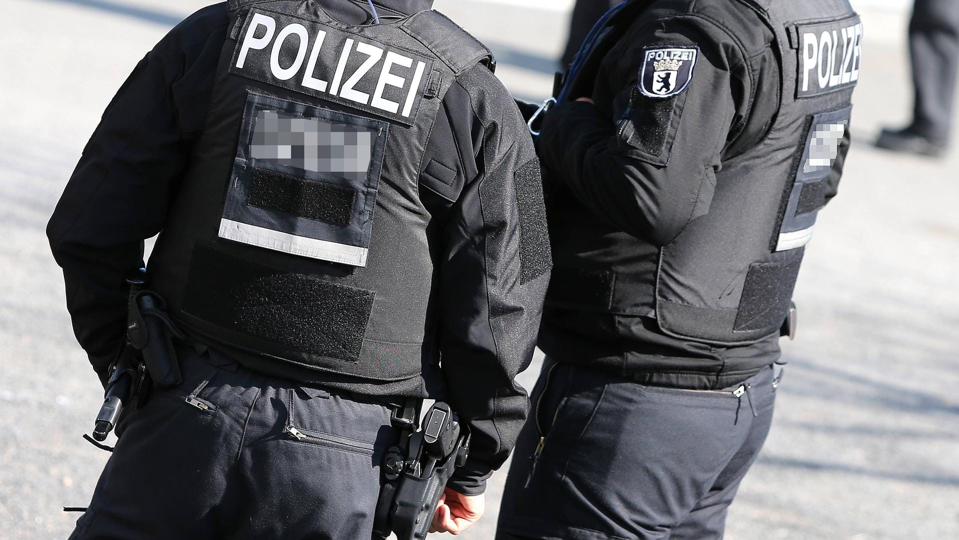 Polizisten von hinten mit Schusswaffe und kugelsicheren Westen: In Berlin hat das SEK eine 17-jährige Diebin gesucht. Polizisten von hinten mit Schusswaffe und kugelsicheren Westen: In Berlin hat das SEK eine 17-jährige Diebin gesucht.