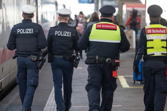 Polizeibeamte und Mitarbeiter der DB-Sicherheit kontrollieren am Stuttgarter Hauptbahnhof die Maskenpflicht.