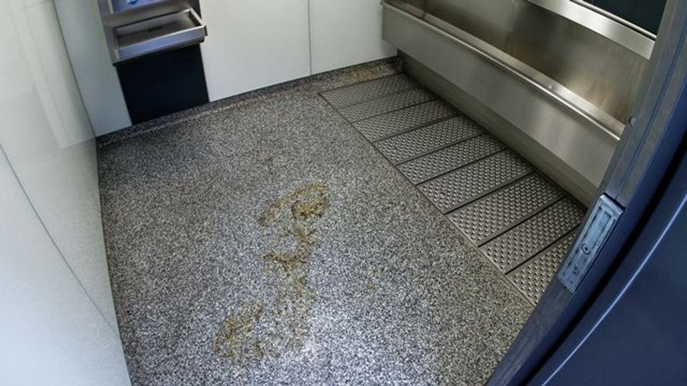 Ein Brandfleck ist am Boden eines Toilettenhäuschens in Köln zu sehen: Dort ist ein Obdachloser offenbar angezündet worden.