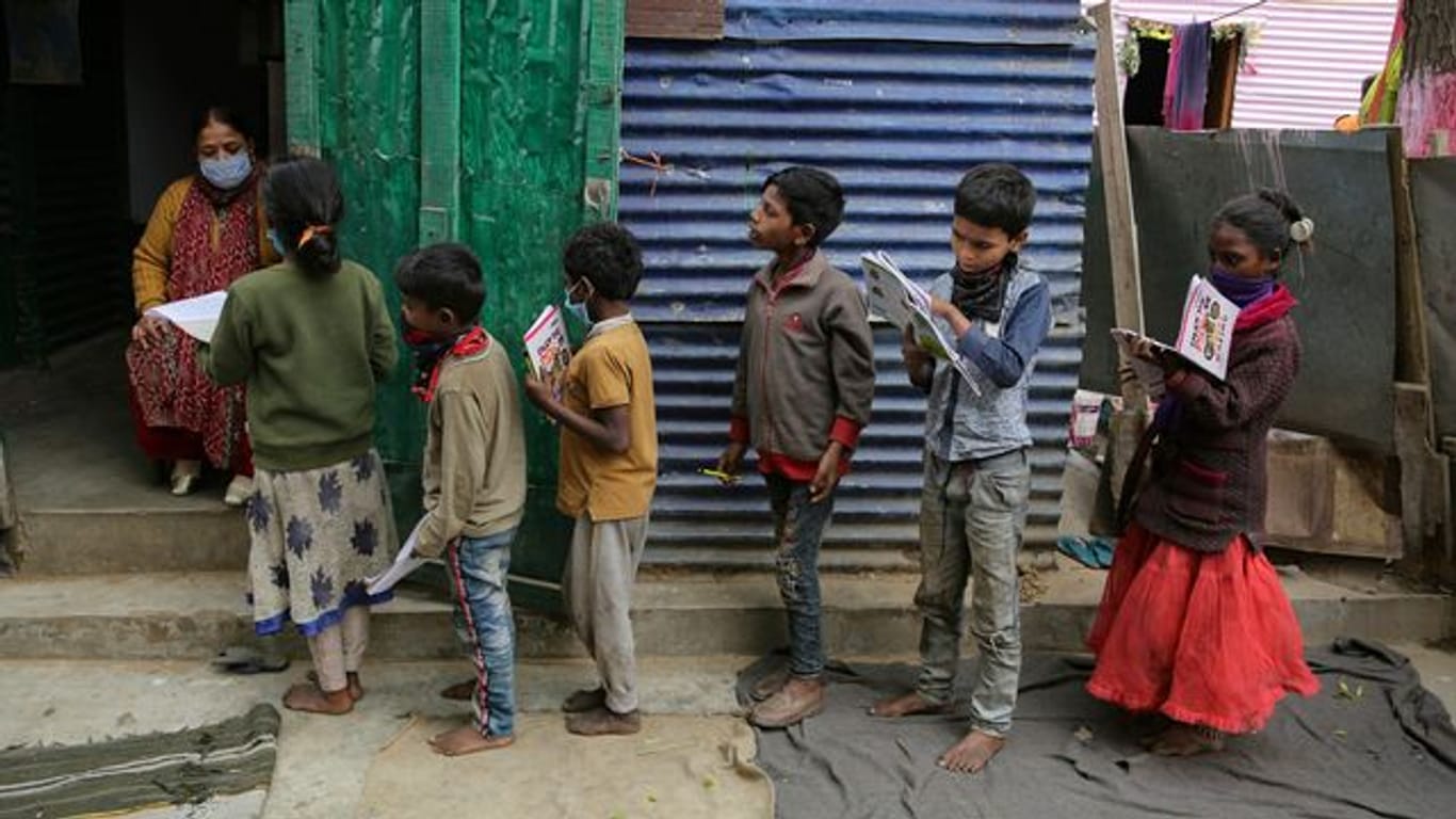 Eine Lehrerin in einem Armutsviertel am Rande der indischen Stadt Jammu korrigiert Schulhefte.