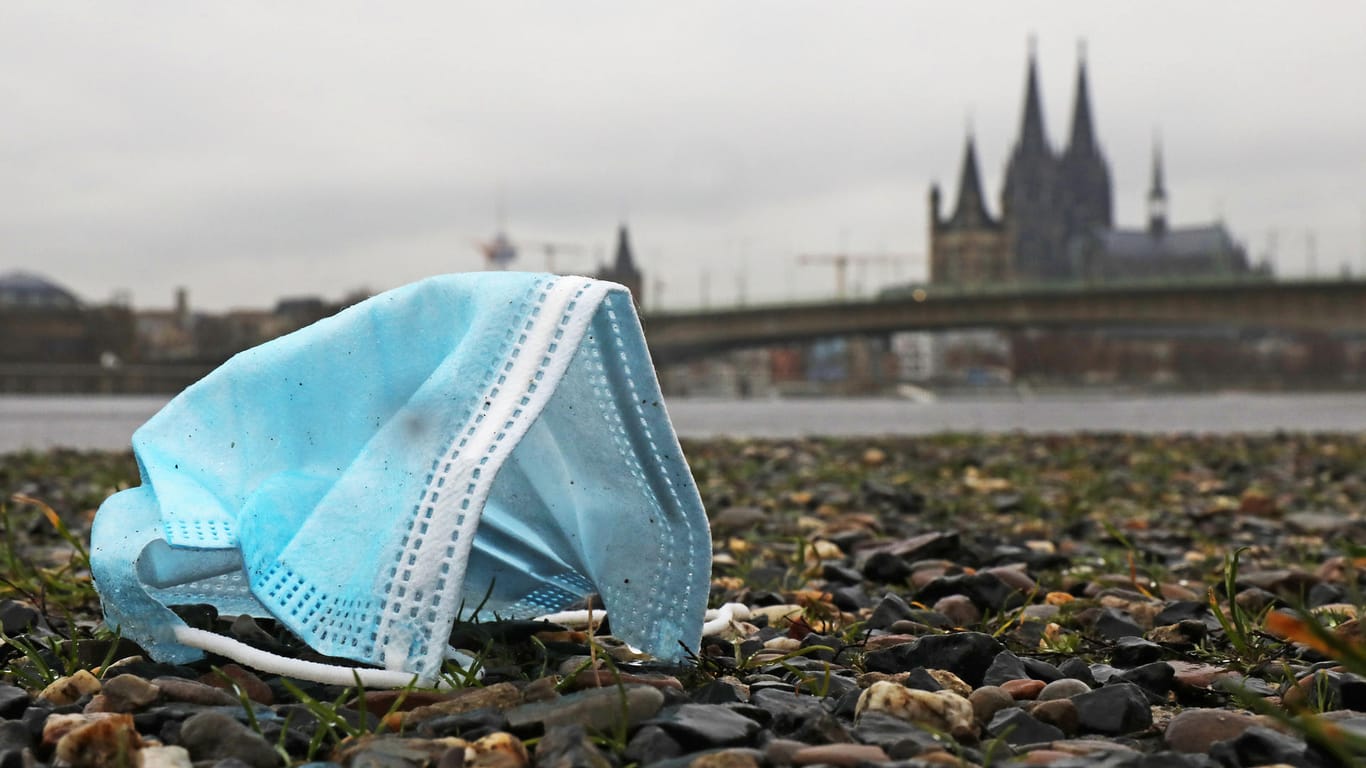 Eine weggeworfene Maske liegt am Rheinufer auf dem Boden: Die Zahl der Neuinfektionen liegt weiter auf hohem Niveau.