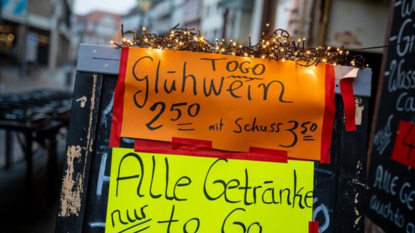 Glühwein "to go" bewirbt eine Kneipe in der Altstadt in Hannover auf einem Werbeaufsteller.