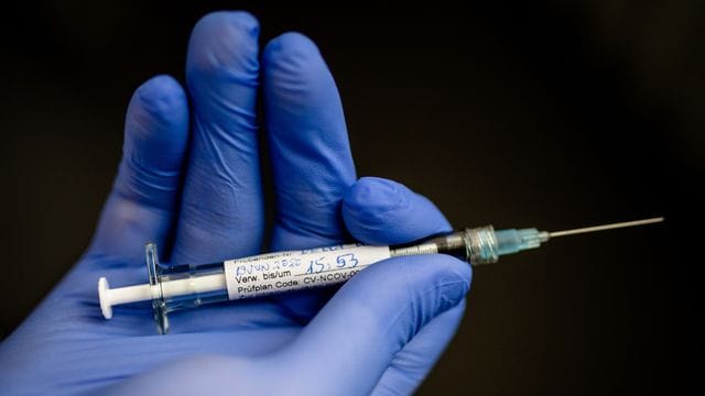 Ein Mann hält eine Spritze in der Hand: In Berlin sollen bald die Impfungen gegen Corona starten – für weniger Menschen als zunächst geplant war. Ein Mann hält eine Spritze in der Hand: In Berlin sollen bald die Impfungen gegen Corona starten – für weniger Menschen als zunächst geplant war.