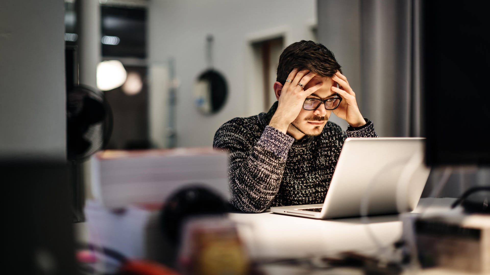 Ein Angestellter blickt erschöpft auf sein Laptop: Erst wenn alle Überstunden abgebaut sind, dürfen Arbeitnehmer Kurzarbeitergeld erhalten.