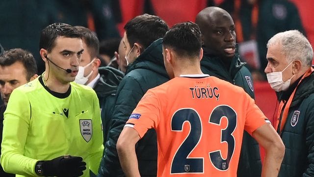 Der rumänische Schiedsrichter Ovidiu Hategan (l) diskutiert mit Verantwortlichen und Spielern von Istanbul Basaksehir und Paris Saint-Germain. Der rumänische Schiedsrichter Ovidiu Hategan (l) diskutiert mit Verantwortlichen und Spielern von Istanbul Basaksehir und Paris Saint-Germain.