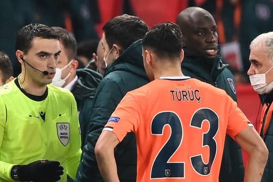 Der rumänische Schiedsrichter Ovidiu Hategan (l) diskutiert mit Verantwortlichen und Spielern von Istanbul Basaksehir und Paris Saint-Germain.