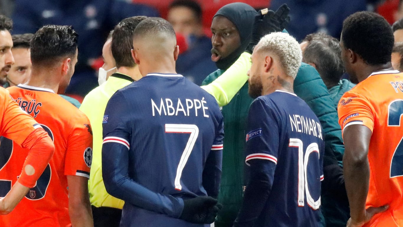 Basaksehir-Stürmer Demba Ba (M.) diskutiert mit Schiedsrichter Hategan, Paris' Mbappé und Neymar sprechen mit.