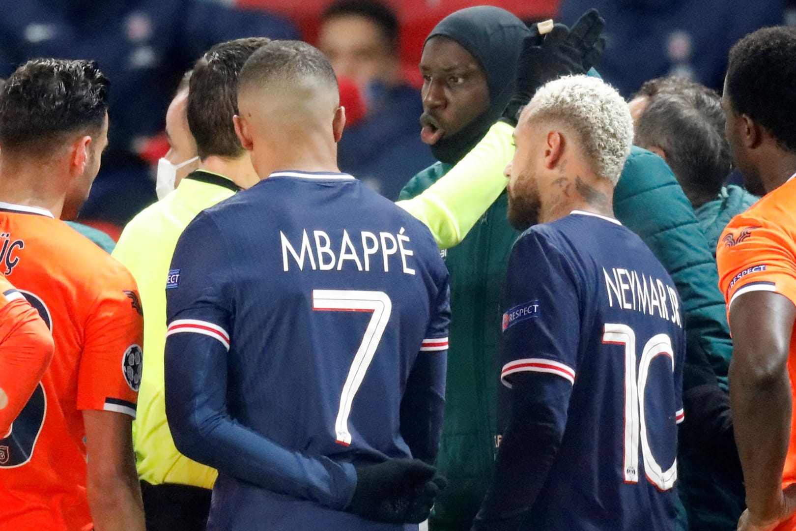 Basaksehir-Stürmer Demba Ba (M.) diskutiert mit Schiedsrichter Hategan, Paris' Mbappé und Neymar sprechen mit.